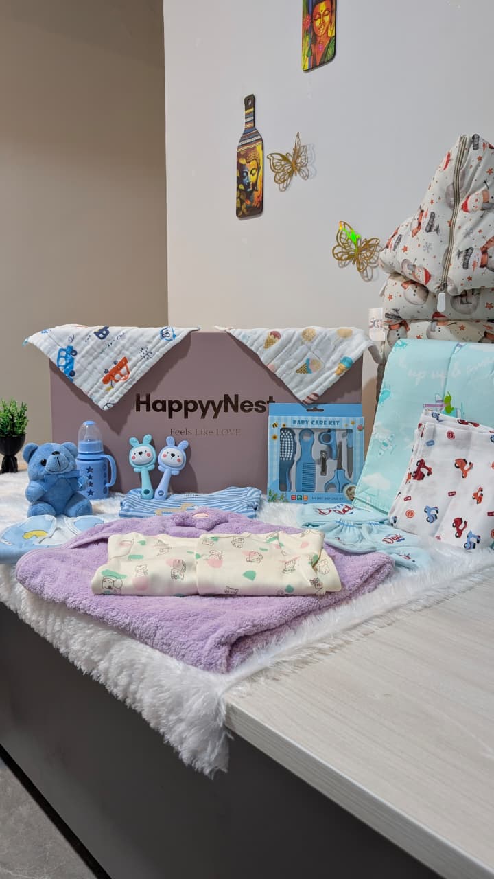 Baby products including blankets and toys on a table with a 'HappyNest' box.